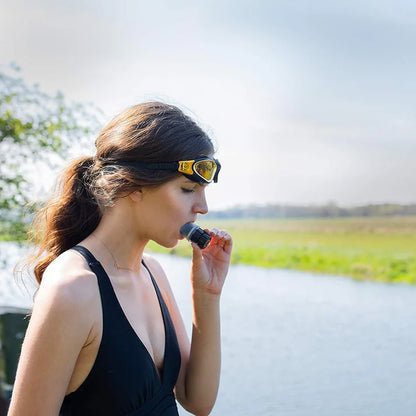 Woman wearing sunglasses and a black dress with a blurred natural background