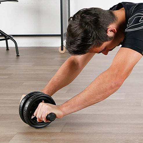 Person using an ab roller on a wooden floor