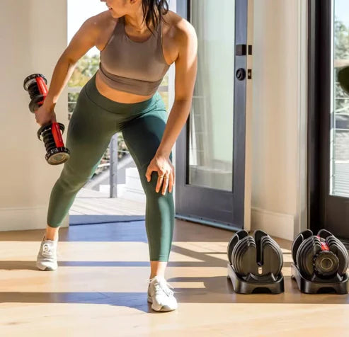Woman exercising with dumbbells in a home setting