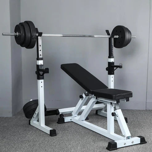 Weight bench with barbell and weights on a gray floor.