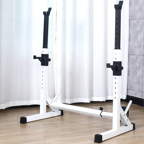 White weight lifting bench with black accents on a wooden floor against a white curtain background