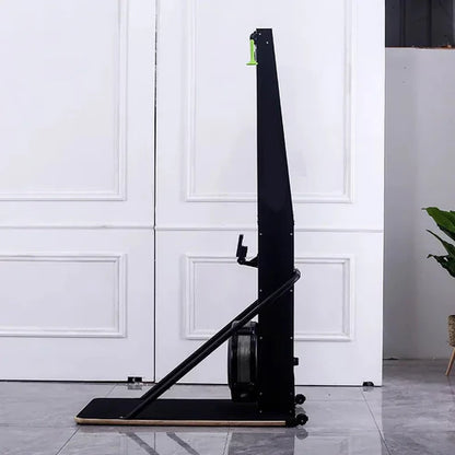 Black rowing machine against a white paneled wall.