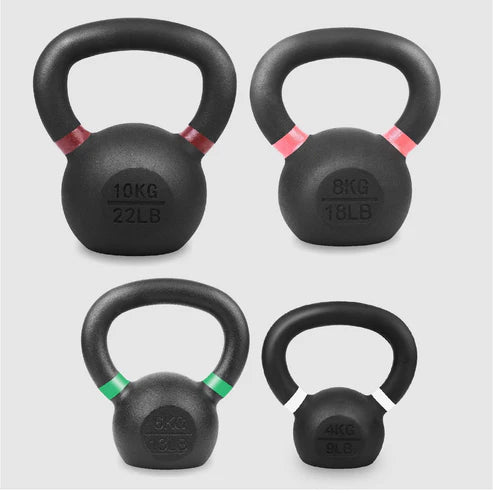 Set of four black kettlebells with weight markings on a light gray background