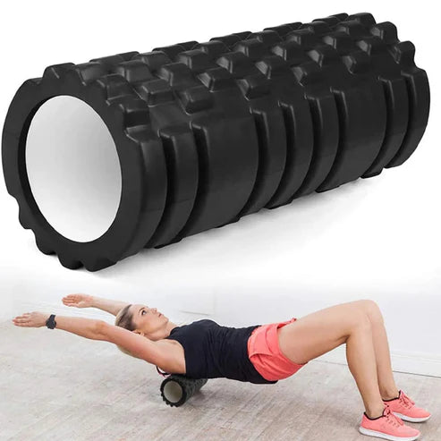 Black foam roller with textured surface and a person using it for exercise on a light background
