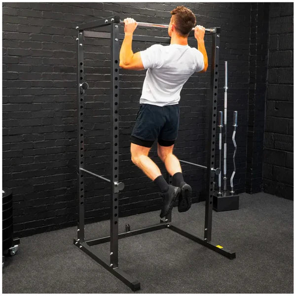 Person using a black power rack in a gym setting