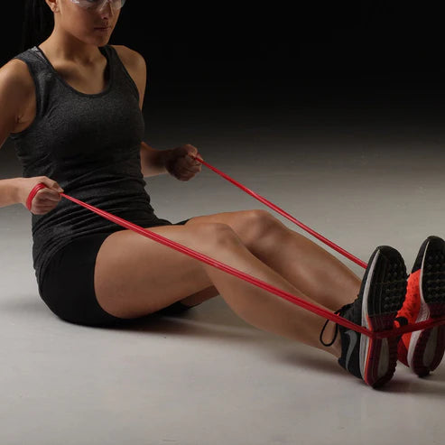 Woman exercising with a resistance band on a dark background