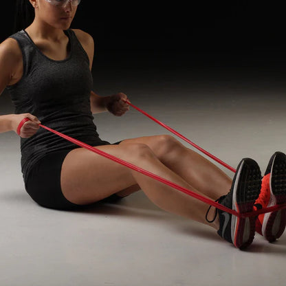 Woman exercising with a resistance band on a dark background