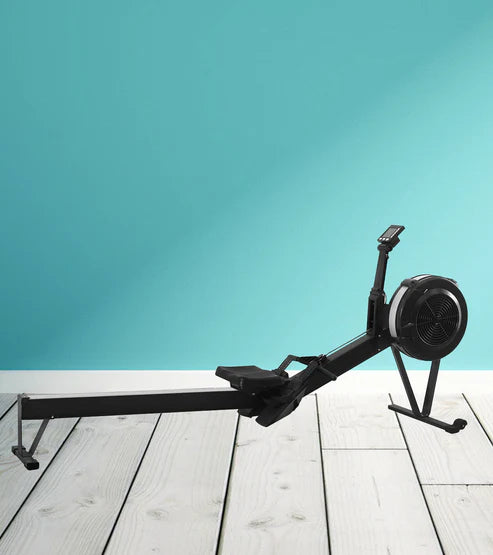 Rowing machine on a wooden floor with a teal wall background