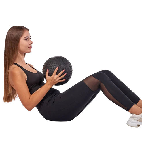 Woman exercising with a medicine ball on a white background