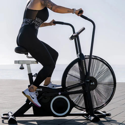 Person using an exercise bike outdoors with a blurred background