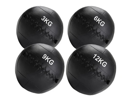 Four black medicine balls with weight markings on a white background