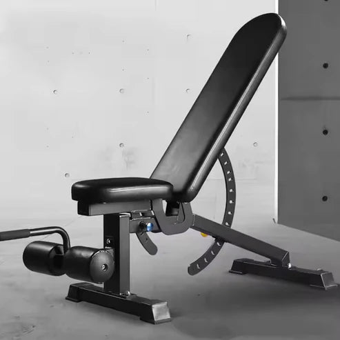 Black adjustable weight bench against a gray concrete wall.